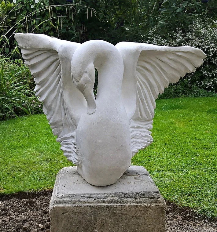 Stone sculpture of a swan in a garden